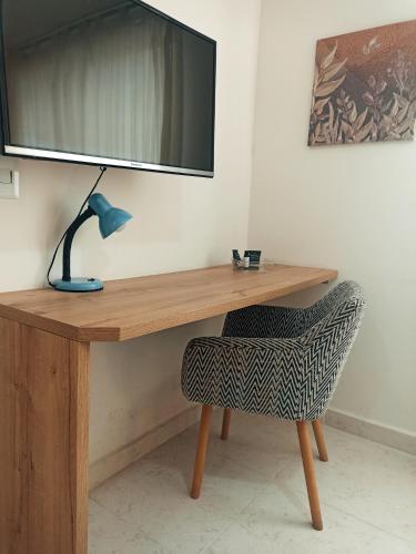 a wooden desk with a lamp and a chair at Laureles Guest House LGH Hotel in Medellín
