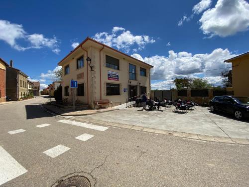 a group of people sitting outside of a building at Albergue El Camino de Santovenia in Santovenia de Oca