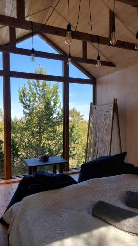 a bedroom with a bed and a large window at Üügumetsa treehouse in Kallaste