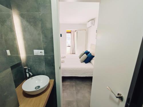 mała łazienka z umywalką i łóżkiem w obiekcie TresBé 1 w mieście Torremolinos