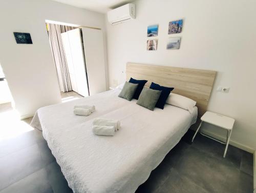 sypialnia z dużym łóżkiem z dwoma ręcznikami w obiekcie TresBé 1 w mieście Torremolinos