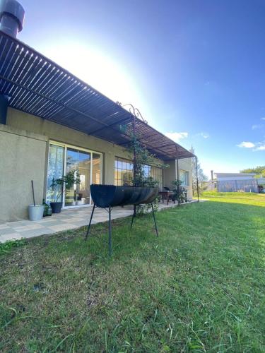 a grill in the grass in front of a house at Casa en Carmelo Golf Club in Carmelo