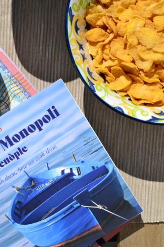 una revista junto a un plato de chips en Carpe Diem B&B e Case Vacanza, en Monopoli