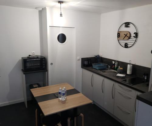 a small kitchen with a table and a sink at Studio 6 in Le Boupère