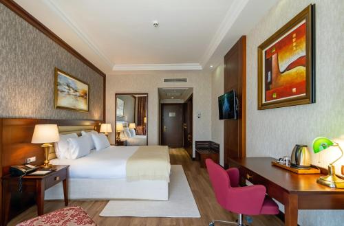 a hotel room with a bed and a desk at Wellborn Luxury Hotel in Kocaeli