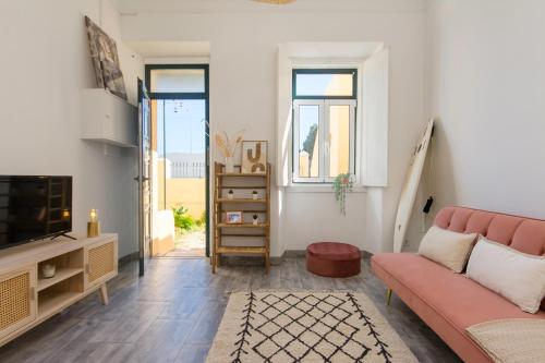 a living room with a couch and a tv at Cozy Apartment with Patio near Carcavelos Beach in Carcavelos