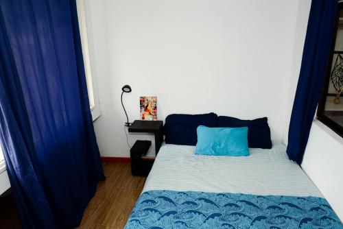a bed in a room with blue drapes at Acogedor Apartamento La Candelaria 2 Habitaciones EC52 in Bogotá