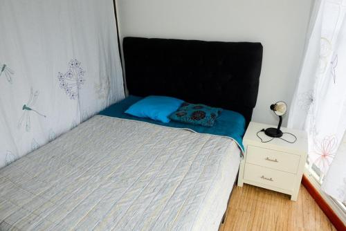 Cama pequeña con almohada azul y mesita de noche en Acogedor Apartamento La Candelaria 2 Habitaciones EC52 en Bogotá