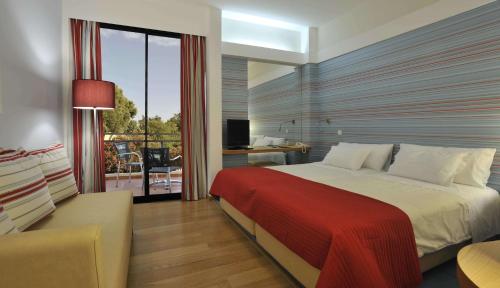 1 dormitorio con 1 cama grande y balcón en Pestana D. João II Beach & Golf Resort, en Alvor