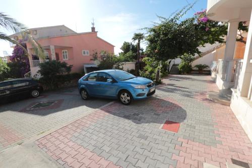 a small blue car parked in a driveway at Apartments Villa Flamingo in Makarska