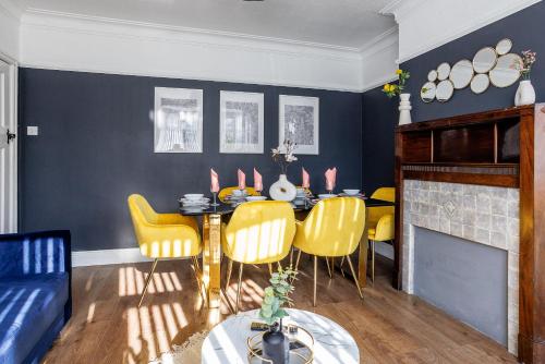 a dining room with a table and yellow chairs at Stylish Newcastle Gem - Sleeps 9 - Parking in Newcastle upon Tyne