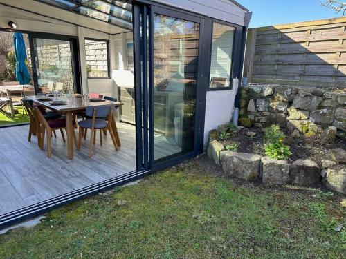 un patio avec une table et des chaises sur une terrasse dans l'établissement La maison de la plage, 600m de la plage, Formule tout inclus, à Erdeven