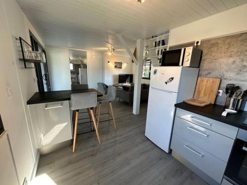 une cuisine avec un réfrigérateur blanc et une table dans l'établissement La maison de la plage, 600m de la plage, Formule tout inclus, à Erdeven