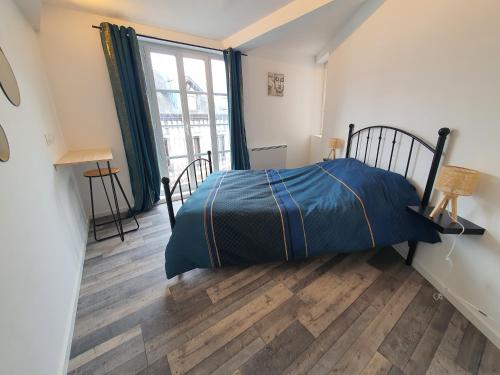 - une chambre avec un lit et une grande fenêtre dans l'établissement Appartement meublé, bord de seine, à Duclair