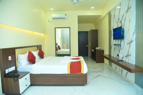 Hotel Royal Inn في Mudhol: غرفة نوم فيها سرير وتلفزيون