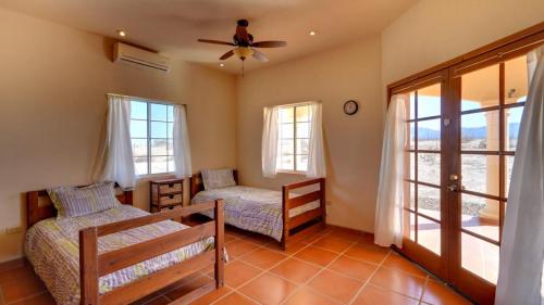 a bedroom with two beds and a ceiling fan at Casa La Vida Dulce - How Sweet Life Can Be in San Felipe