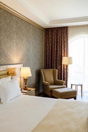 a hotel room with a bed and a chair at Wellborn Luxury Hotel in Kocaeli
