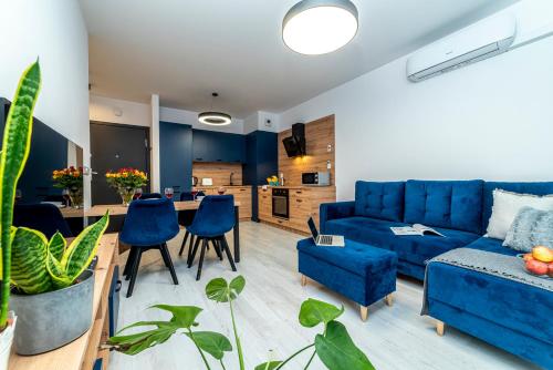 a living room with a blue couch and a table at Premium Wrocławska Apartament Parking in Bydgoszcz
