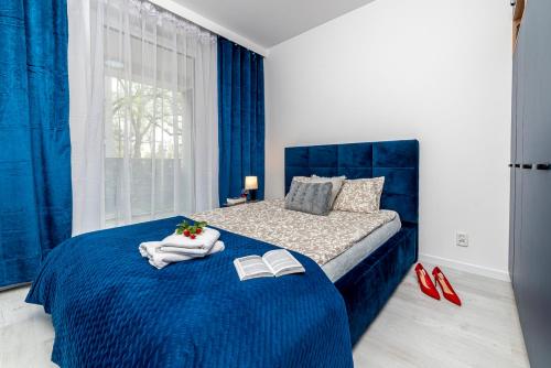 a bedroom with a blue bed with two books at Premium Wrocławska Apartament Parking in Bydgoszcz