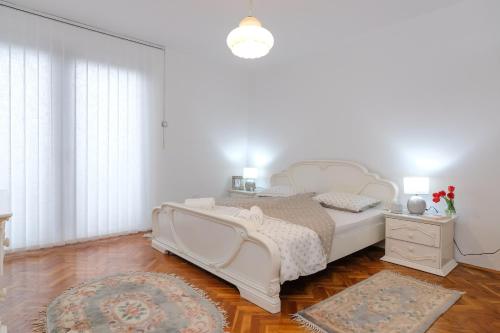 a white bedroom with a white bed and a rug at The Cosmic Gate Apartments in Visoko