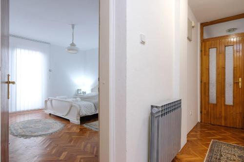 a bedroom with a bed and a hallway with a radiator at The Cosmic Gate Apartments in Visoko