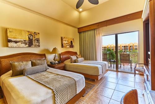 a bedroom with two beds and a balcony at The Royal Haciendas Resort & Spa in Playa del Carmen