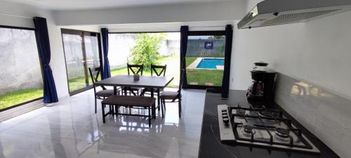 a kitchen with a table and chairs and a stove at Casa Jardín Real in Temixco