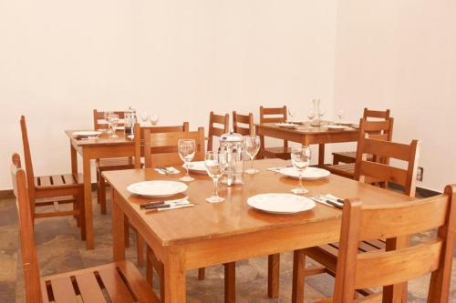 a dining room with wooden tables and chairs with wine glasses at CASONA DON LUCAS in Tarapoto