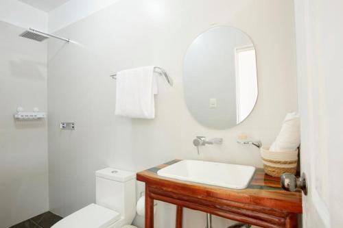 W białej łazience znajduje się umywalka i lustro. w obiekcie CASONA DON LUCAS w mieście Tarapoto