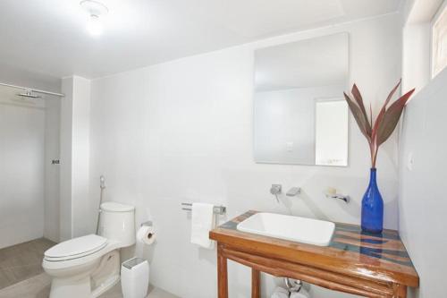 a bathroom with a sink and a toilet and a blue vase at CASONA DON LUCAS in Tarapoto