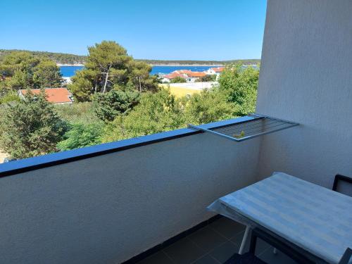 a balcony with a table and a view of the water at MIRKO DIVING CENTER in Rab