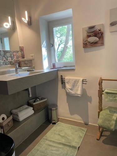 La salle de bains est pourvue d'un lavabo, d'une fenêtre et de serviettes. dans l'établissement Ermitage Notre Dame de Vacquieres, à Noves