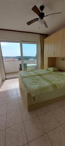 a bedroom with a bed and a ceiling fan at MIRKO DIVING CENTER in Rab
