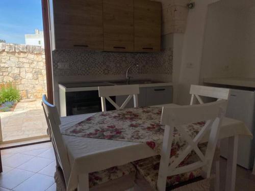 une cuisine avec une table avec deux chaises et un évier dans l'établissement Casa Nonna Renzina, à Locorotondo