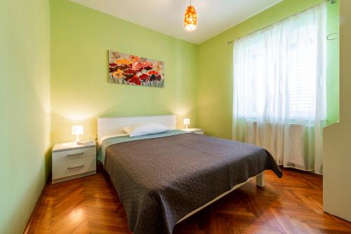 zieloną sypialnię z łóżkiem i oknem w obiekcie Apartment Miljas w mieście Cavtat