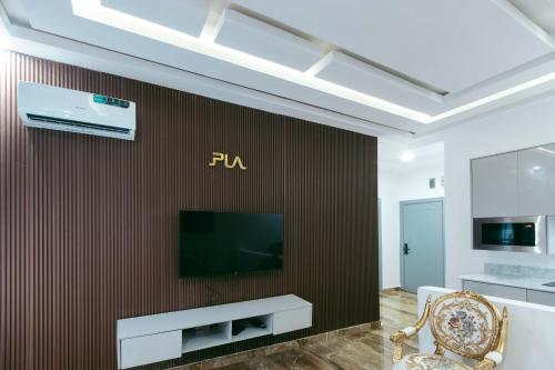 a living room with a television on a wall at Phoenix Luxury Apartments in Abuja