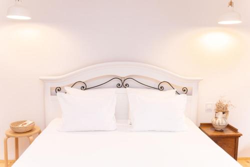 a bedroom with a white bed with white pillows at Casa Milina in Šibenik