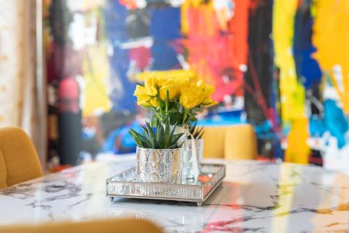 a vase of yellow flowers sitting on a table at L'Avant Scène Meublé 5 étoiles Parking Gratuit Jacuzzi in Avignon