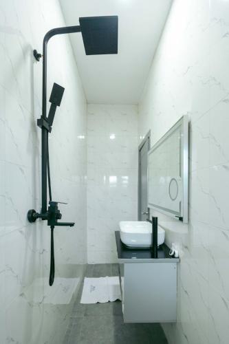 a white bathroom with a sink and a mirror at Phoenix Luxury Apartments in Abuja