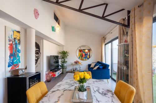 a living room with a table and yellow chairs at L'Avant Scène Meublé 5 étoiles Parking Gratuit Jacuzzi in Avignon