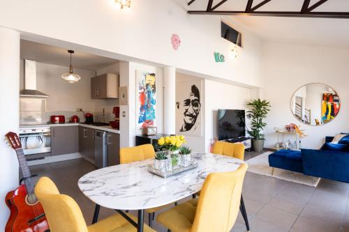 una cucina e un soggiorno con tavolo e sedie di L’Avant Scène - Loft de Luxe - Atelier d'artiste ad Avignone
