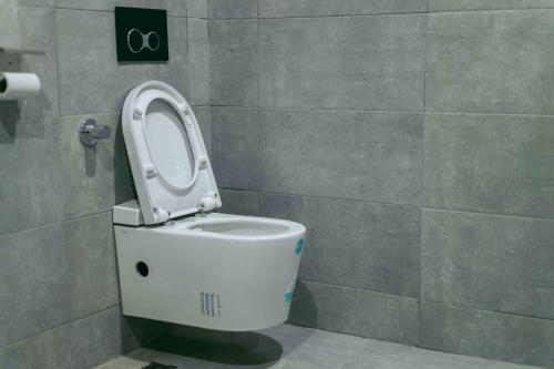a bathroom with a toilet with the seat up at Phoenix Luxury Apartments in Abuja