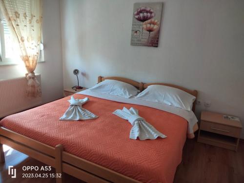 a bedroom with a bed with two dresses on it at Apartman Nikolic,Banja Vrucica,Teslic in Teslić