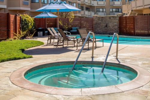 a small pool with an umbrella and chairs and a table at The Lodge at Tiburon in Tiburon