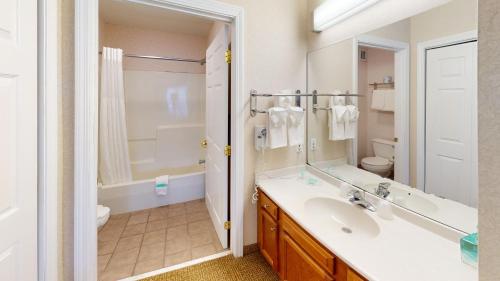 a bathroom with a sink and a toilet and a mirror at Smart Suites, Ascend Hotel Collection in Burlington