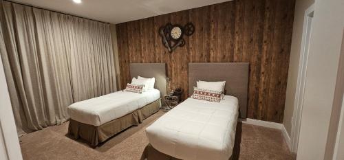 a bedroom with two beds and a clock on the wall at Magic Village 4 Bedroom! Welcome Home! in Orlando