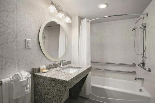 a bathroom with a sink and a tub and a mirror at Comfort Inn Williamsburg Gateway in Williamsburg