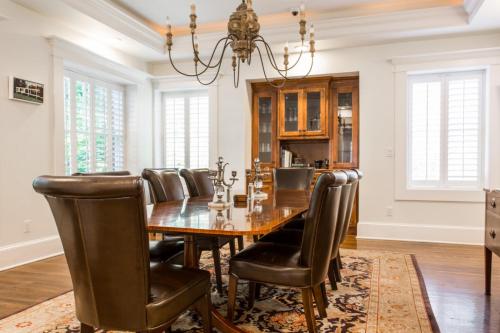 uma sala de jantar com uma mesa e cadeiras de couro em Crestwood at Oak Street Mansion em Kansas City