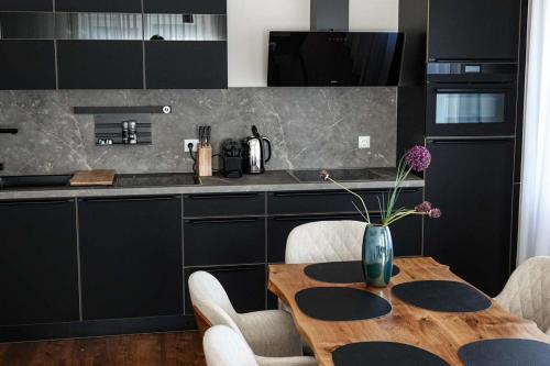 a kitchen with a wooden table with a vase of flowers on it at Residence Black Eagle Lubmin Strand in Lubmin