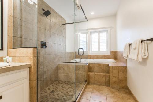 a bathroom with a shower and a tub at Valentine at Oak Street Mansion in Kansas City